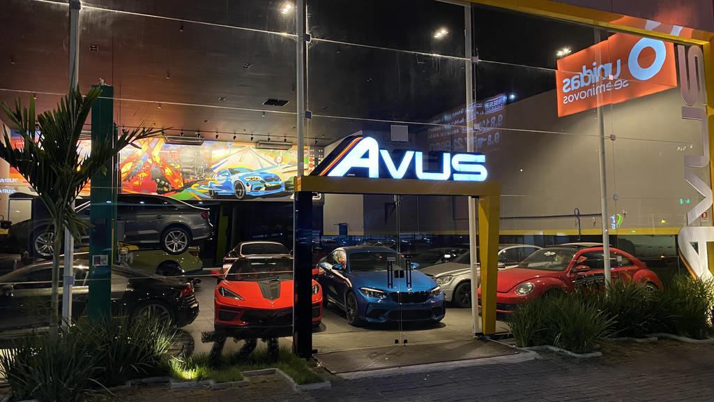 Fachada de loja de vidro, com carros de luxo e neon escrito Avus, que é uma empresa especializada em Stage 1 